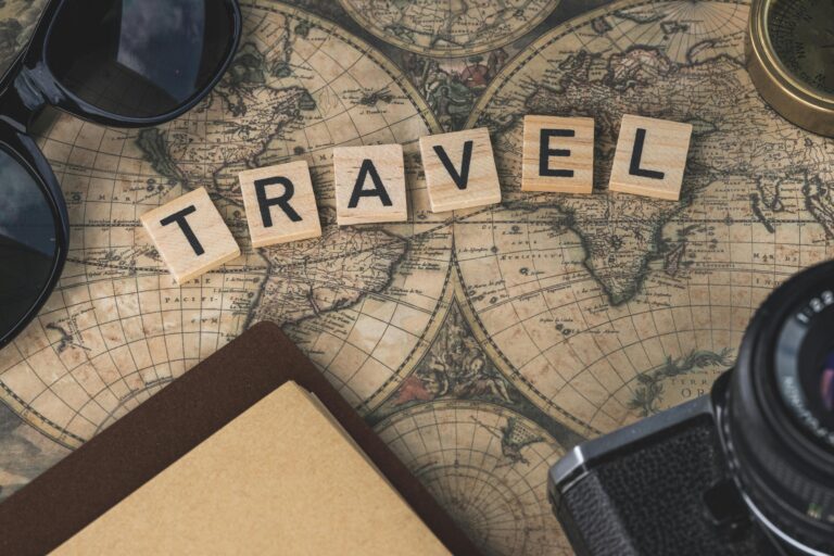 Vintage map with travel essentials like camera and sunglasses arranged in a flat lay, perfect for adventure themes.